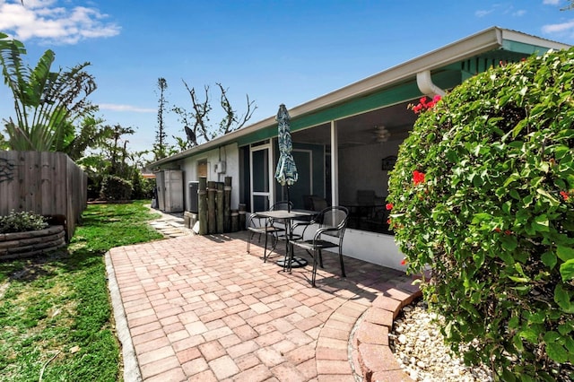 view of patio with fence and a sunroom