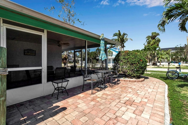 view of patio / terrace with ceiling fan and a sunroom