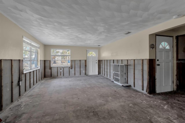 unfurnished living room with visible vents and wainscoting