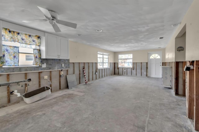 interior space featuring visible vents, concrete flooring, and ceiling fan