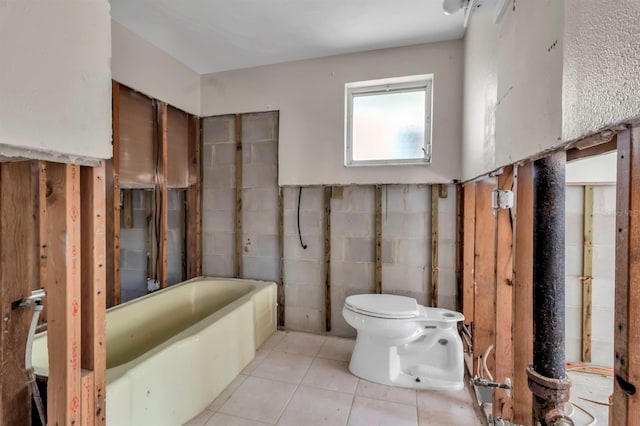 full bathroom featuring tile patterned floors, toilet, and a bathtub