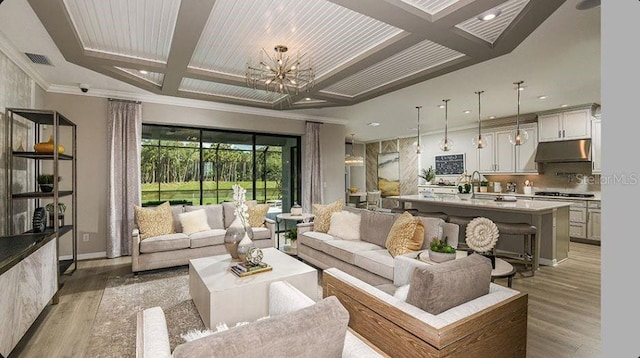 living room with visible vents, coffered ceiling, light wood-style floors, an inviting chandelier, and crown molding