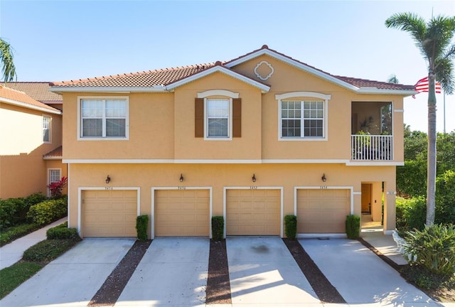 townhome / multi-family property with stucco siding, driveway, and a garage