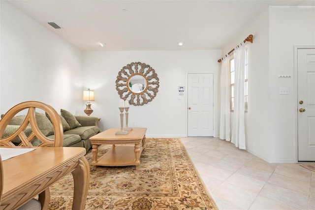 living room with visible vents, baseboards, and light tile patterned flooring