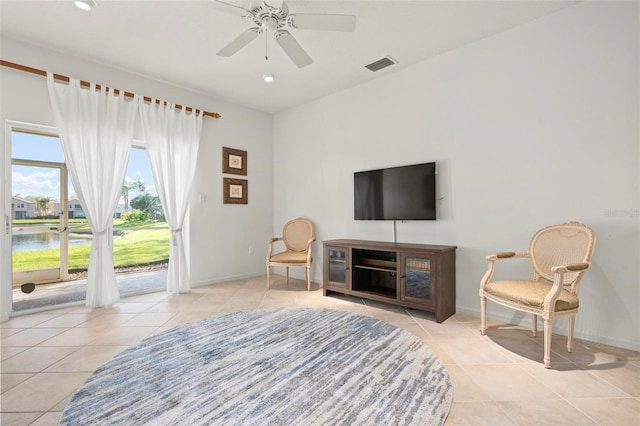 living area featuring tile patterned floors, visible vents, baseboards, and ceiling fan