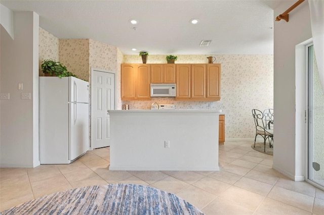 kitchen with light tile patterned floors, visible vents, white appliances, and wallpapered walls