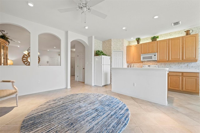 kitchen featuring visible vents, a kitchen island, recessed lighting, white appliances, and a ceiling fan