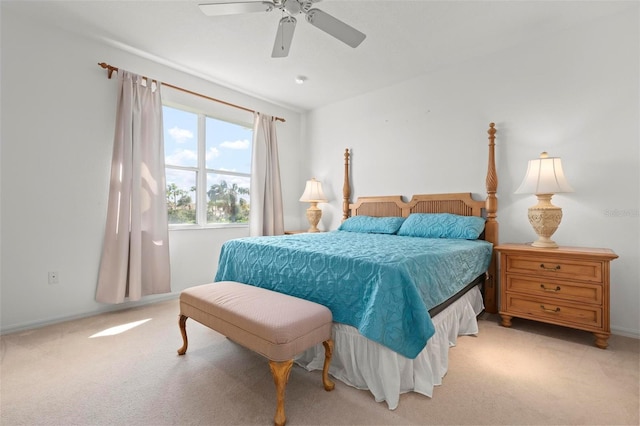 bedroom featuring light colored carpet, baseboards, and a ceiling fan