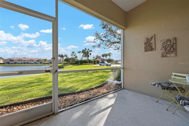 sunroom featuring a residential view and a water view