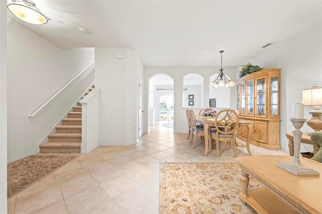 3456 Parkridge Cir Unit 33-105, Sarasota, FL 34243 - dining space with arched walkways, stairs, light tile patterned floors, and a chandelier