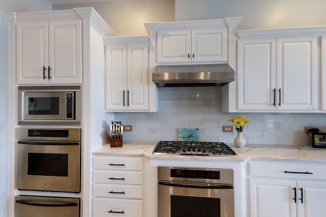 kitchen featuring stainless steel appliances, tasteful backsplash, under cabinet range hood, a warming drawer, and white cabinetry