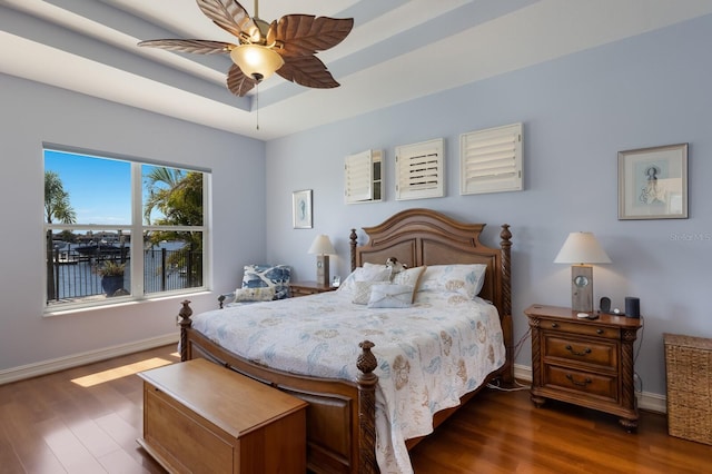 bedroom with ceiling fan, baseboards, and dark wood-type flooring