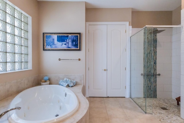 bathroom with a stall shower, tile patterned flooring, and a whirlpool tub