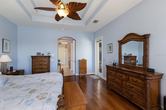 1009 3rd St E, Palmetto, FL 34221 - bedroom with arched walkways, a tray ceiling, dark wood-style floors, ceiling fan, and baseboards