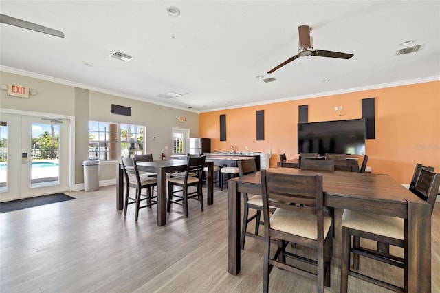 1009 3rd St E, Palmetto, FL 34221 - dining room featuring french doors, light wood-style flooring, crown molding, ceiling fan, and recessed lighting