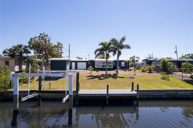 dock area with a yard, a water view, and boat lift