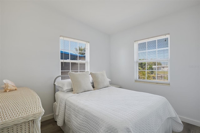 bedroom featuring dark wood finished floors and baseboards