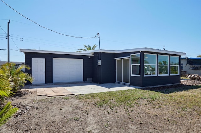 mid-century inspired home with an attached garage and driveway