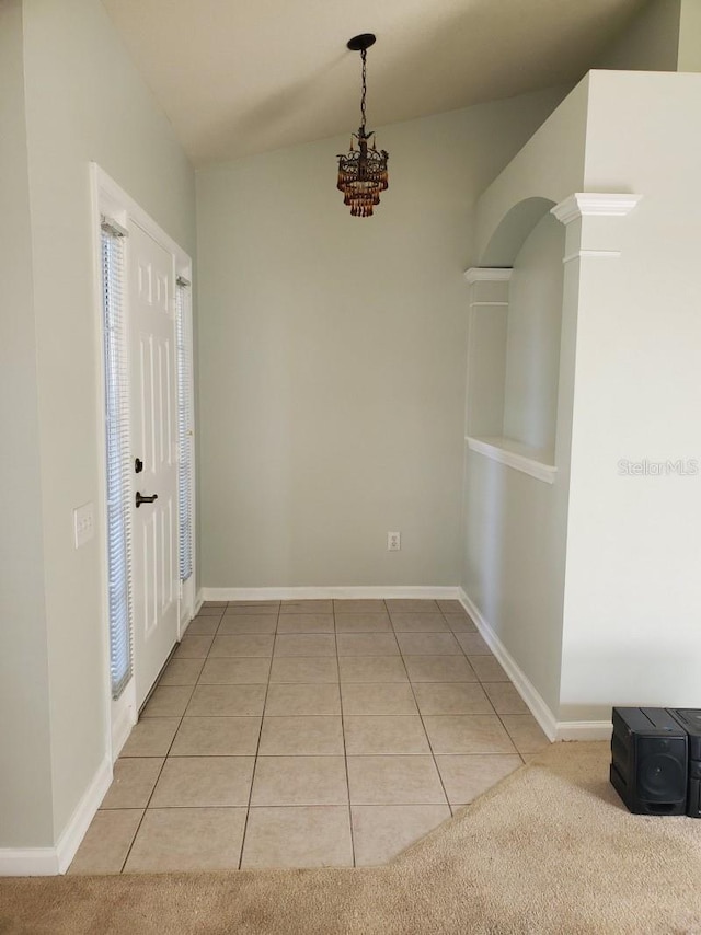 interior space with light tile patterned floors, a chandelier, and baseboards