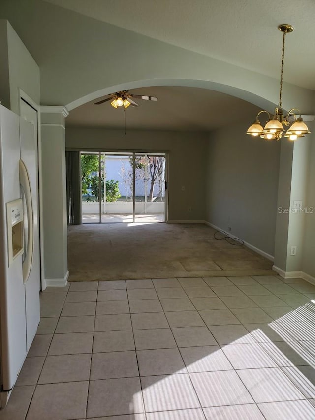 interior space featuring vaulted ceiling, light tile patterned flooring, ceiling fan with notable chandelier, and arched walkways