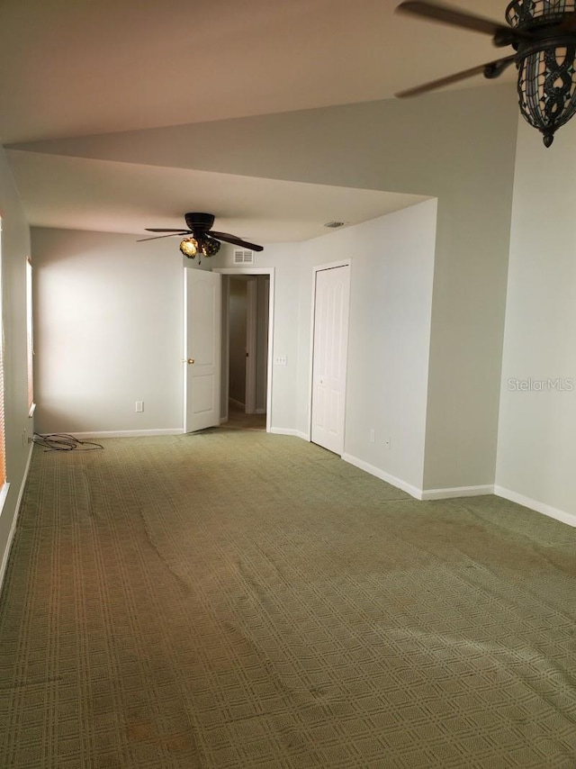 carpeted spare room featuring baseboards and ceiling fan