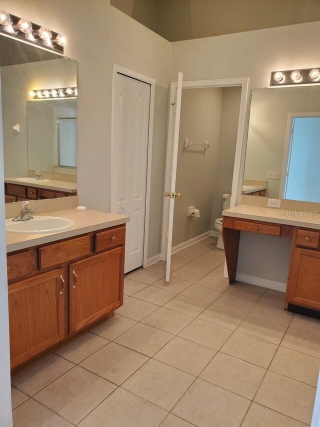 full bathroom with vanity, tile patterned floors, toilet, and baseboards