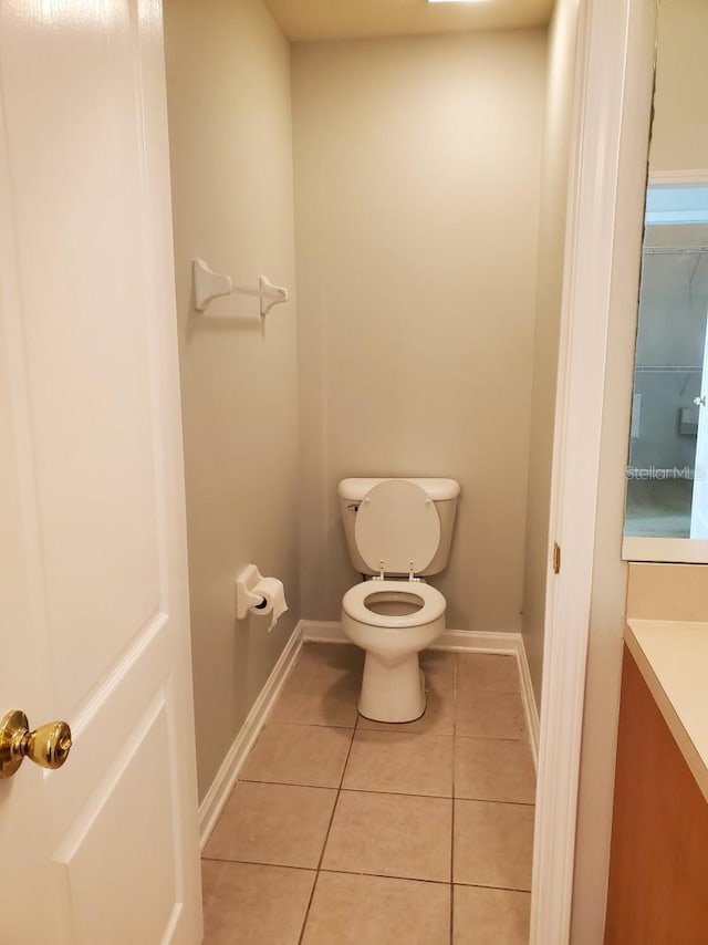 bathroom featuring vanity, tile patterned floors, toilet, and baseboards