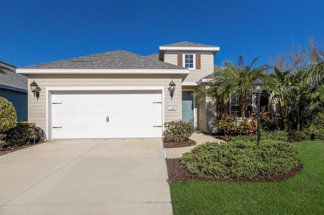 view of front facade featuring a garage, driveway, and a shingled roof