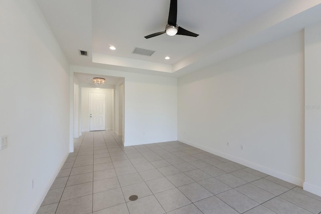 empty room featuring baseboards, visible vents, recessed lighting, ceiling fan, and a raised ceiling