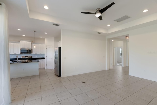 kitchen with dark countertops, visible vents, open floor plan, stainless steel appliances, and a ceiling fan