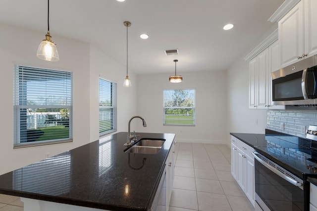 kitchen with visible vents, backsplash, white cabinets, stainless steel appliances, and a sink