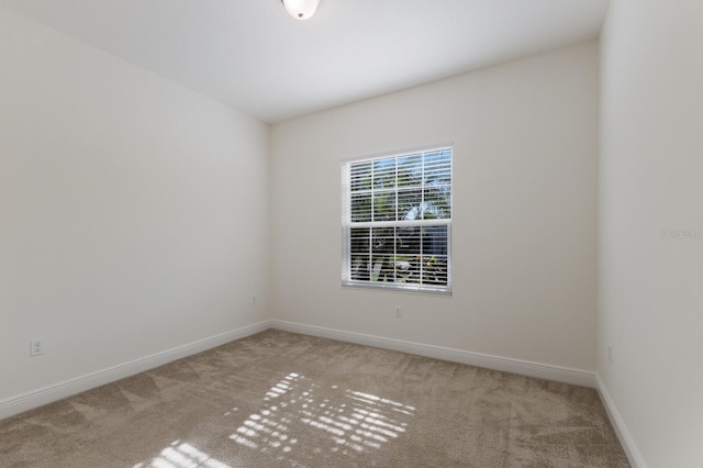 carpeted empty room featuring baseboards