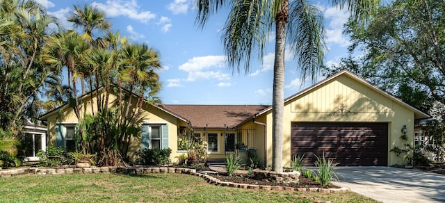 ranch-style home with an attached garage, stucco siding, a shingled roof, concrete driveway, and a front lawn