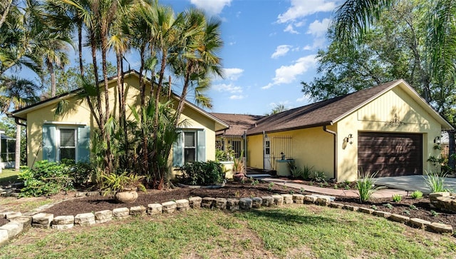 view of front of property featuring stucco siding, concrete driveway, and a garage