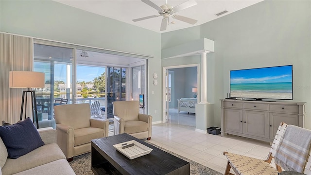 living area featuring visible vents, light tile patterned floors, baseboards, ceiling fan, and ornate columns