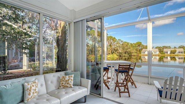 sunroom featuring vaulted ceiling and a water view