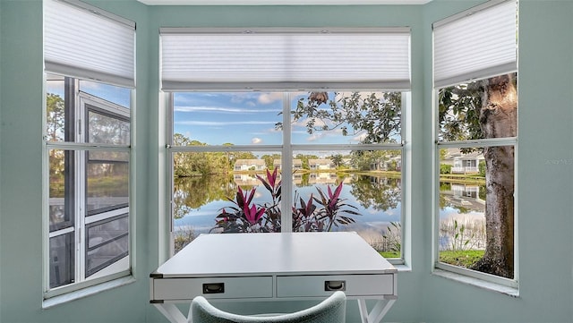 sunroom featuring a water view