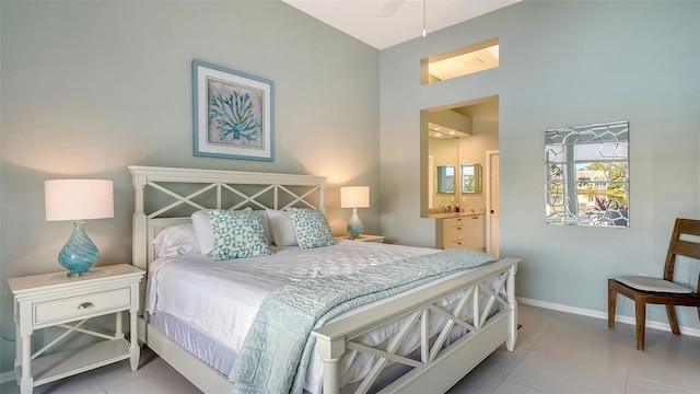 bedroom featuring tile patterned floors, baseboards, and connected bathroom