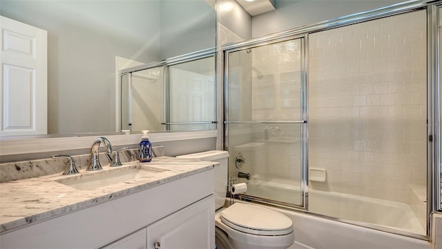 bathroom featuring combined bath / shower with glass door, toilet, and vanity