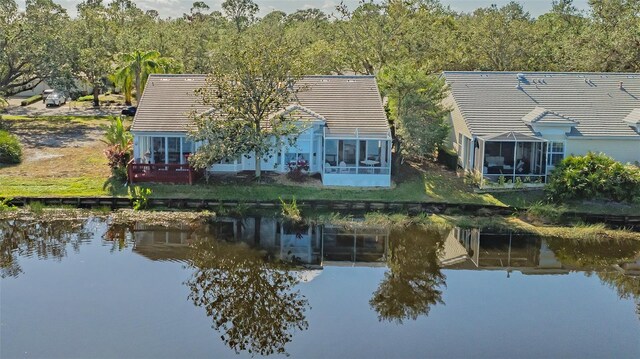 exterior space featuring a tile roof and a water view