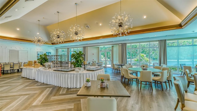 dining space with a tray ceiling, visible vents, a towering ceiling, and a chandelier