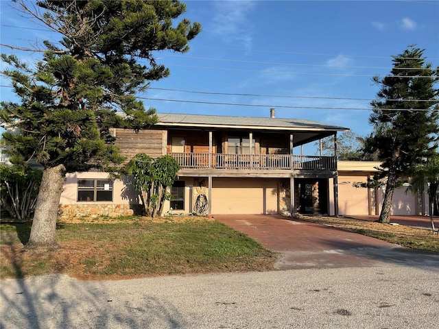 view of front of house featuring a front lawn, stucco siding, a garage, stone siding, and driveway