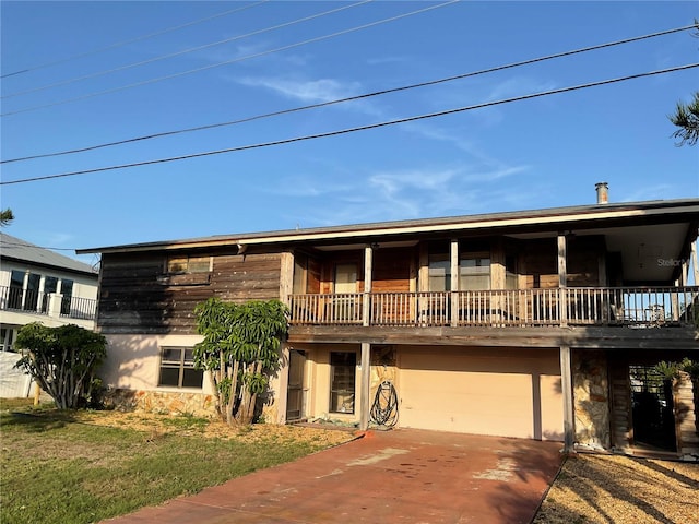 view of front facade featuring an attached garage, stone siding, and driveway