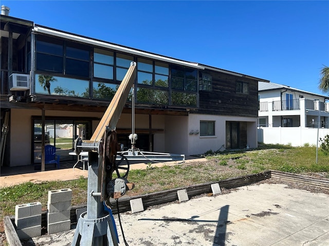 back of property with stucco siding and cooling unit