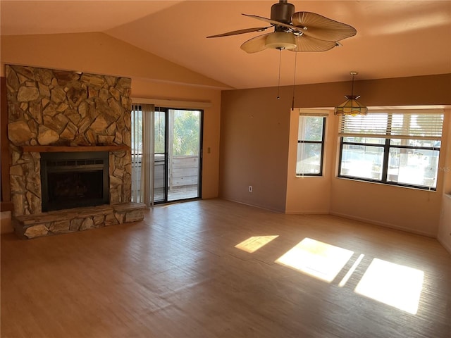 unfurnished living room featuring a ceiling fan, vaulted ceiling, a fireplace, and light wood-style floors