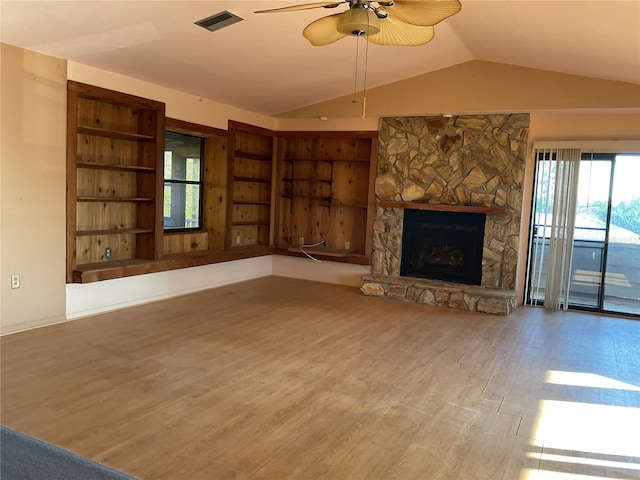 unfurnished living room featuring visible vents, wood finished floors, a fireplace, ceiling fan, and vaulted ceiling