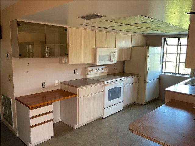 kitchen with white appliances, light brown cabinets, and visible vents