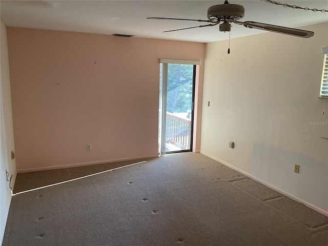 unfurnished room with visible vents, carpet floors, baseboards, and a ceiling fan