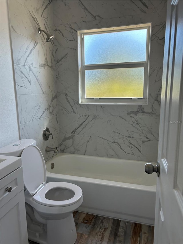 bathroom with vanity, toilet, wood finished floors, and shower / bathtub combination