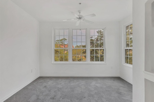 empty room with baseboards, plenty of natural light, carpet floors, and a ceiling fan